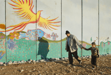 Padre e hijo pasean junto a la frontera israelí