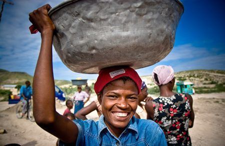 Una mujer haitiana acarreando agua. Foto. Living Water International