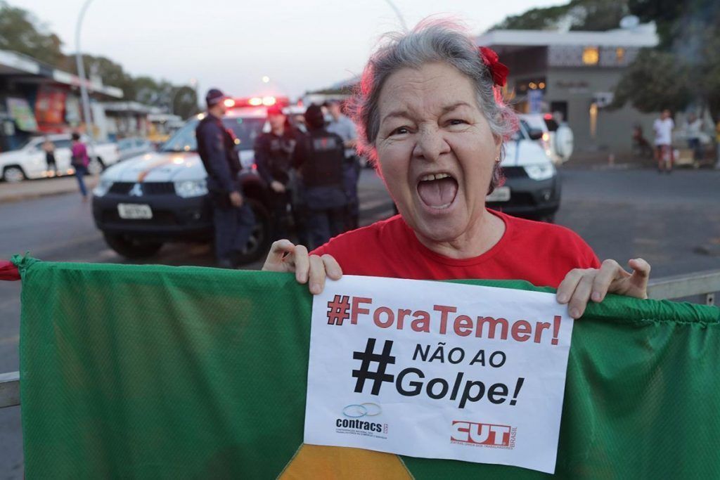Una mujer muestra una pancarta en la que se lee “Fuera Temer, no al golpe” durante una manifestación de apoyo a Dilma Rousseff en Brasilia. Foto. AP Photo / Eraldo Peres
